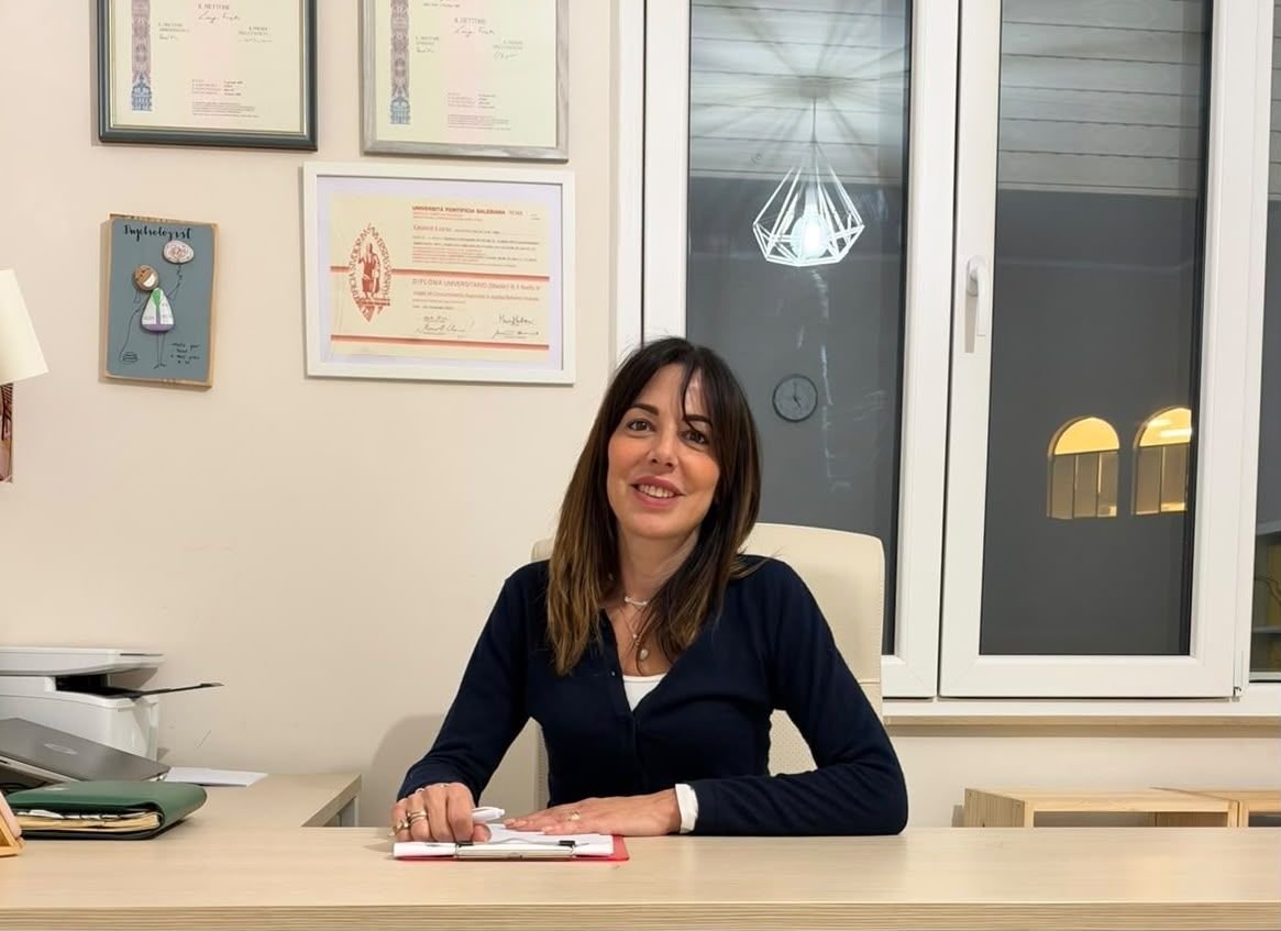 Luna Grassi alla scrivania del suo studio a PSICOMOTIVAlab, con i diplomi alle pareti